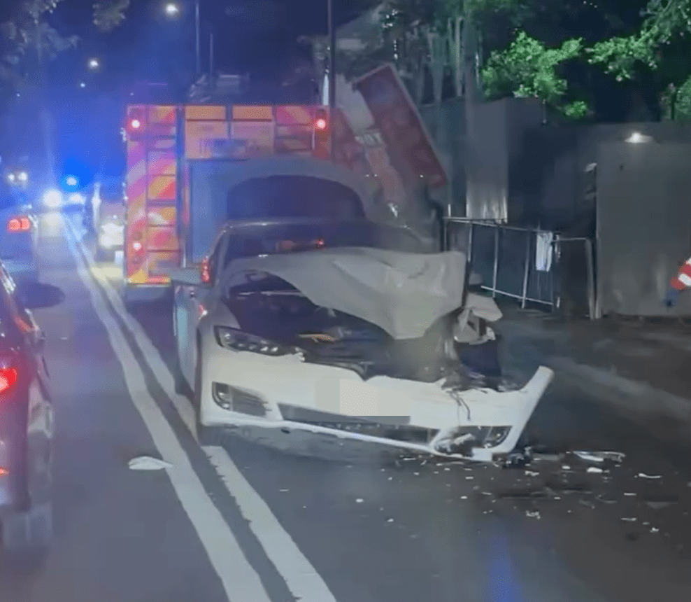 涉事Tesla車頭嚴重損毀,引擎蓋拱起變形,泵把幾乎整幅脫落,頭燈及車頭組件亦撞毀。Facebook「大埔人大埔谷」影片截圖 涉事Tesla車頭嚴重損毀,引擎蓋拱起變形,泵把幾乎整幅脫落,頭燈及車頭組件亦撞毀。Facebook「大埔人大埔谷」影片截圖