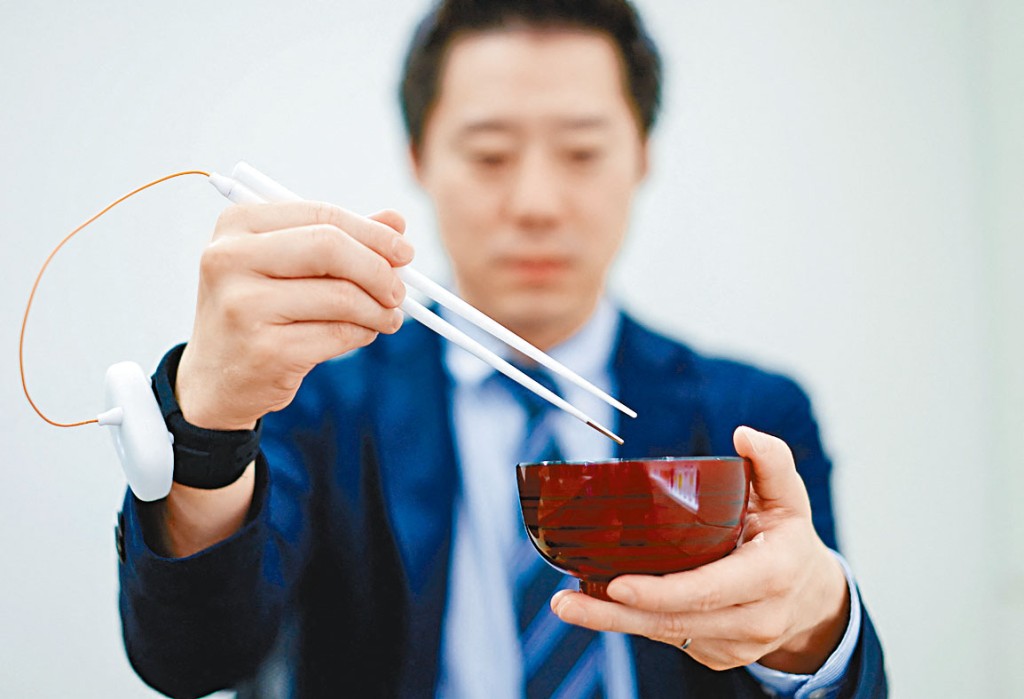 日本麒麟控股公司職員, 示範使用提升鹹味的電子筷子。