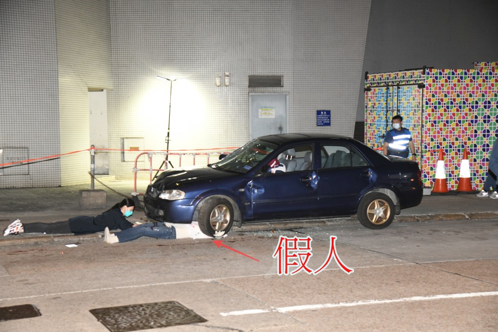 假人輾壓車底，在旁女親友大聲呼救:「救命呀！你唔好死呀！快啲救佢啦！」李家傑攝