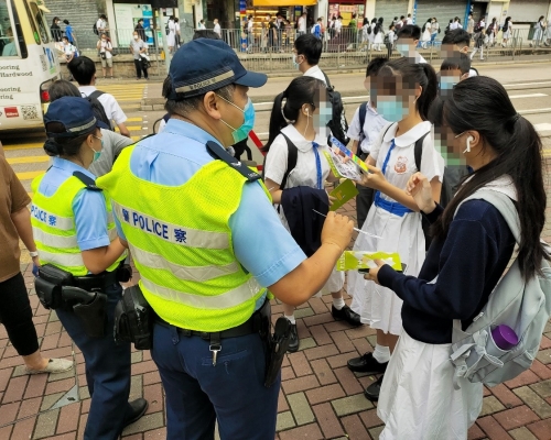 警員派發宣傳單張,呼籲學童及家長善用過路設施小心過馬路。 警方圖片