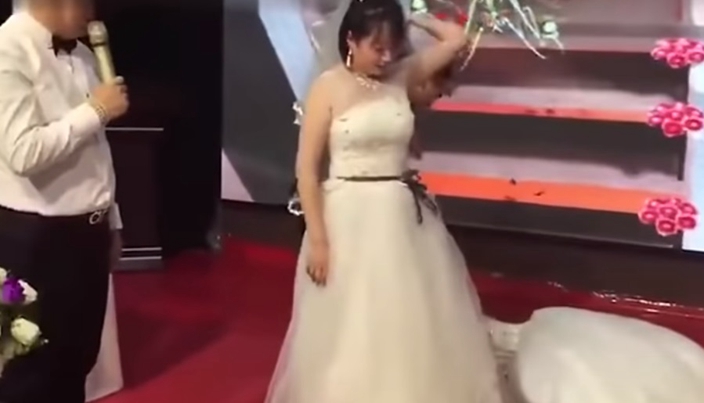 新娘怒而摔開他的手。影片截圖