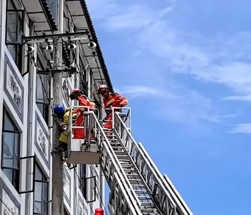 雲南有維修工在高空中暑，被困電線桿吊吊揈，要消防員架起雲梯救回。