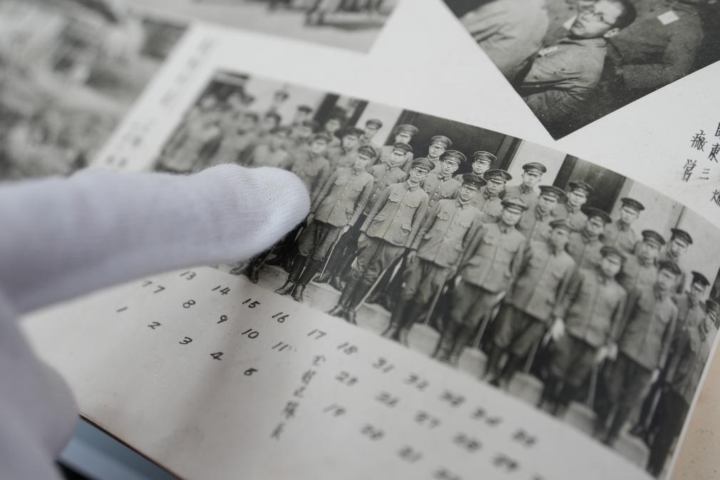 工作人員展示侵華日軍相關相冊（影印件）。新華社