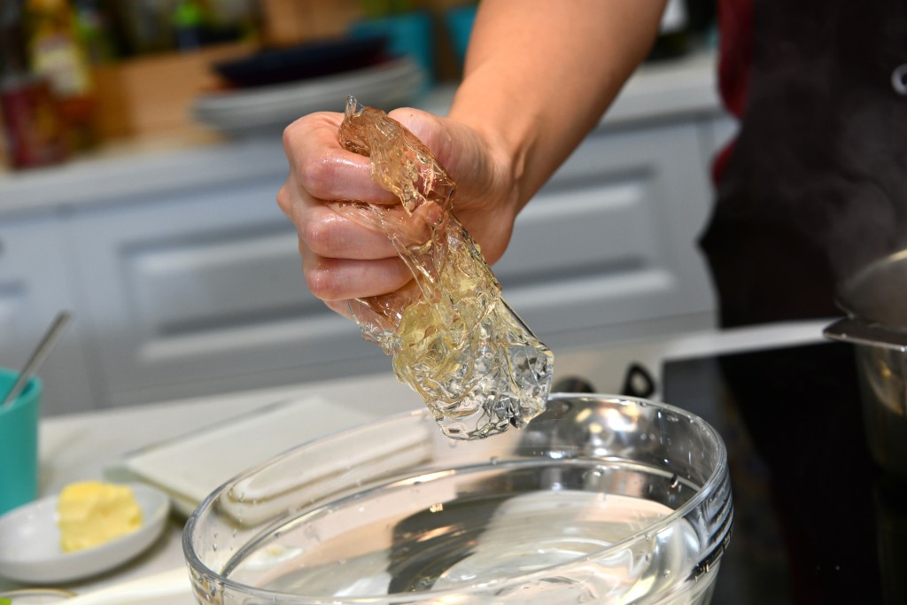 Step 4: 魚膠片揸乾水分，放入鍋內拌至煮融，熄火。Squeeze out the excess water from the gelatin sheets, put them in a pot and stir until dissolved, turn off the heat.
