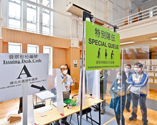■選舉事務處人員向工作人員講解投票站內的排隊安排。