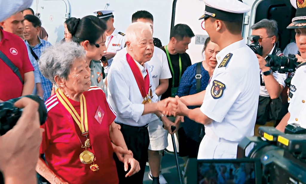 两名原东江纵队抗日老战士参观湛江舰，大赞海军力量能保卫祖国。