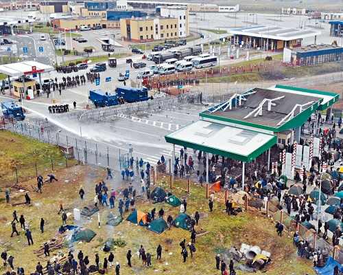 波蘭警察昨日以水炮試圖驅散從白俄邊境湧入的非法移民。