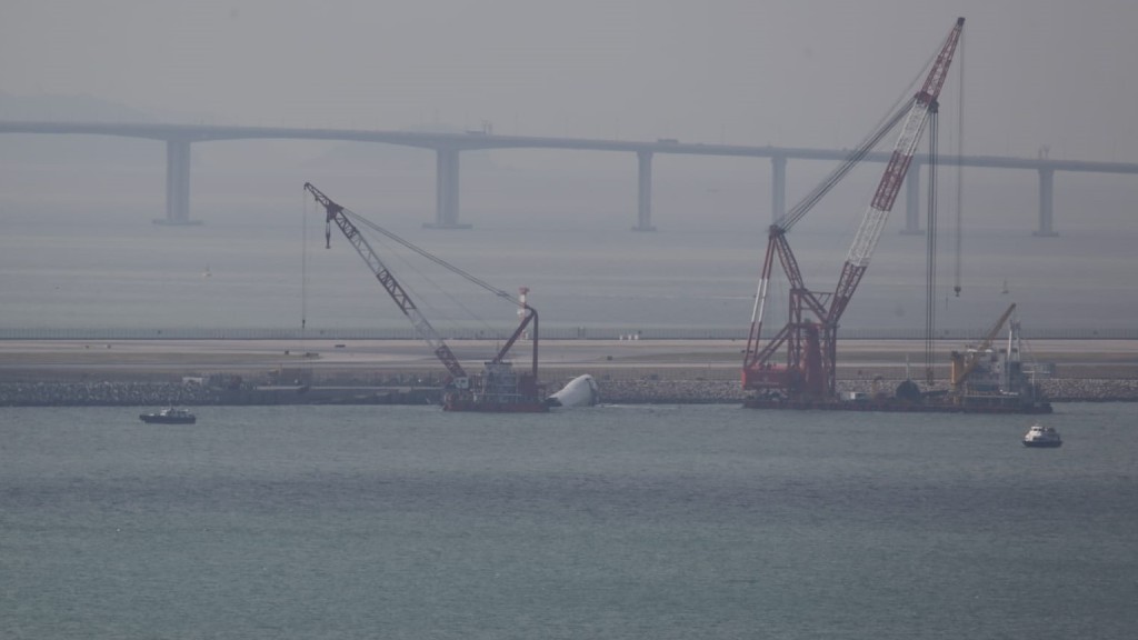 打撈船吊起被撞落海的巡邏車。 打撈船吊起被撞落海的巡邏車。