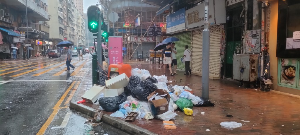 汝州街街头垃圾筒被塞爆，部分垃圾满溢弃于路边。