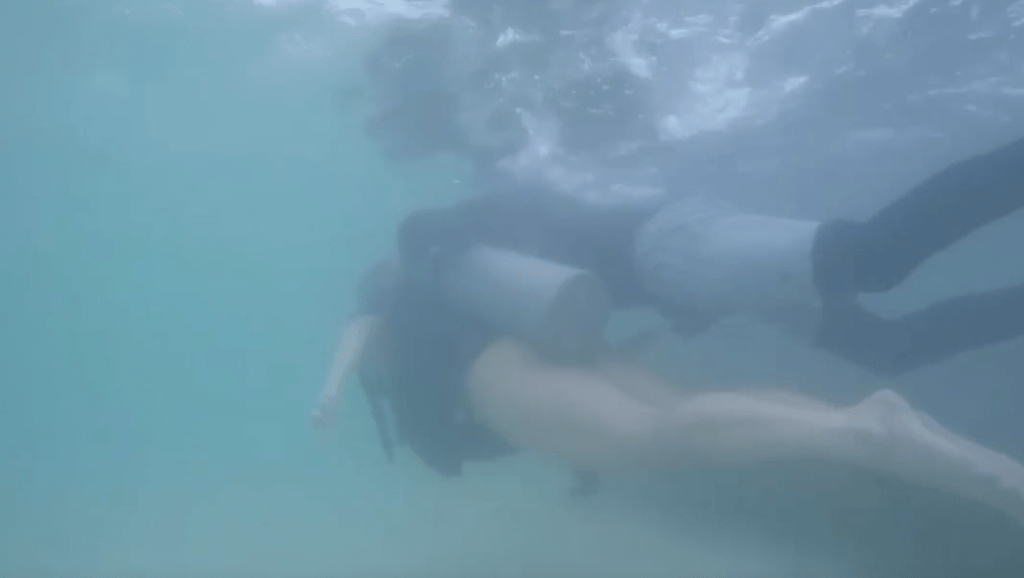 一名女遊客指控巴西一名潛水教練,在帶領她體驗潛水期間,竟貼着她在水下手淫,被相機意外拍下。圖為二人潛水初段時情景。