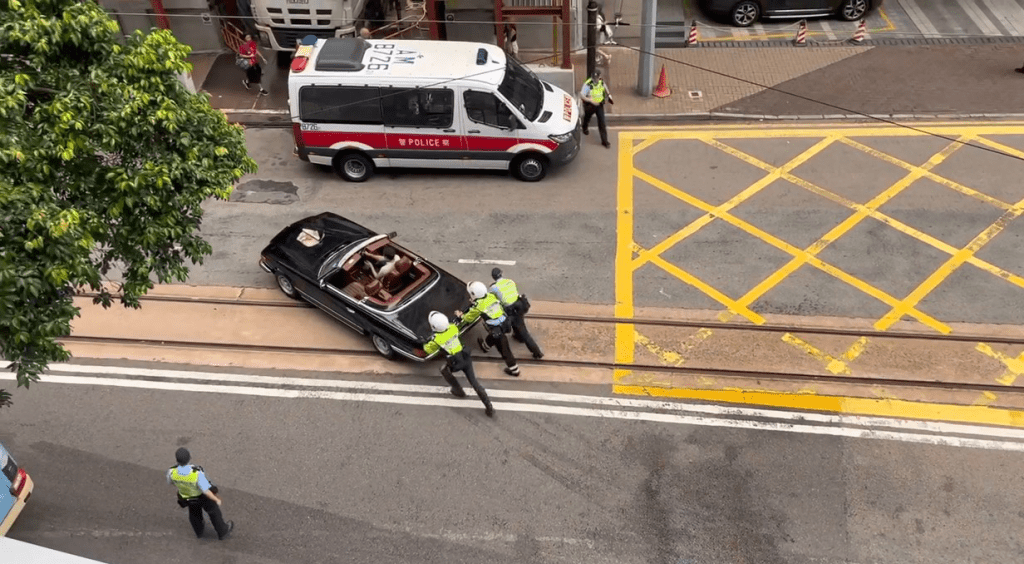 3名警員合走將車推回路邊。網上圖片 3名警員合走將車推回路邊。網上圖片