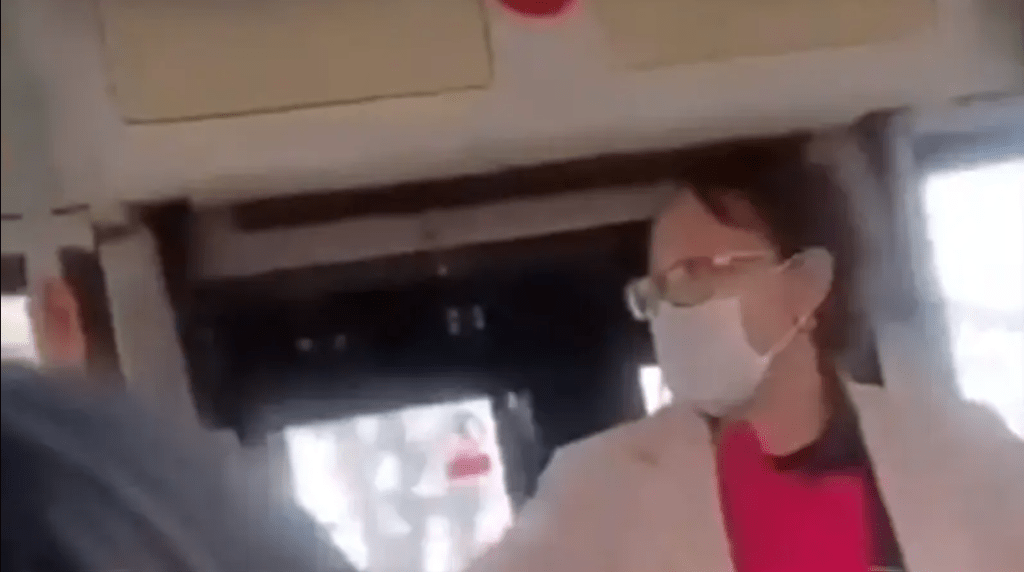 网传影片显示，巴士上女子唱完歌向乘客索歌酬，拦在车门前，有乘客欲将其拉开。