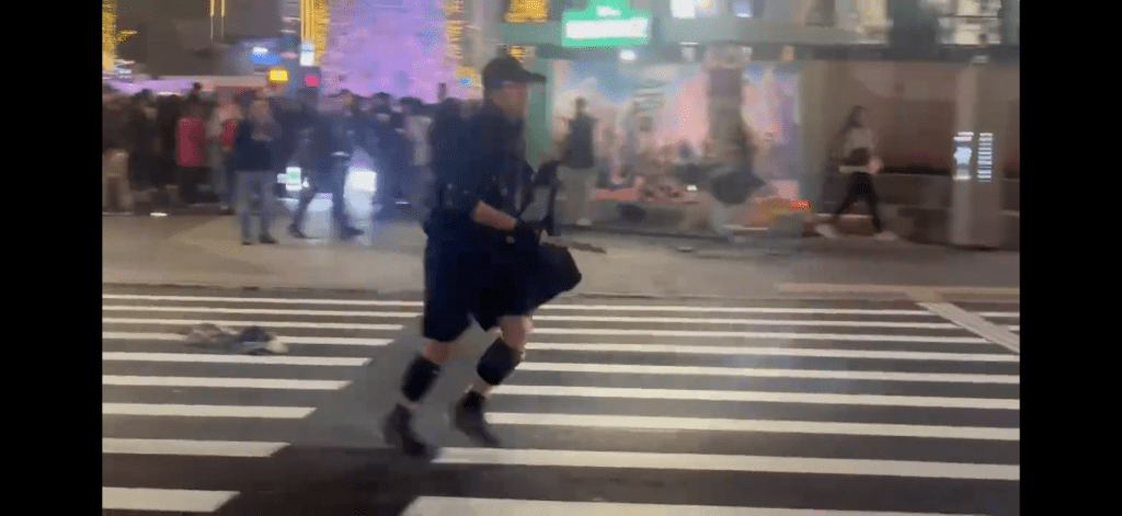 張文持刀走向人群。