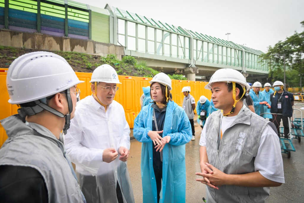 卓永興（左二）向地區服務及關愛隊伍義工了解工作的情況。旁為王婉蓉（右二）。