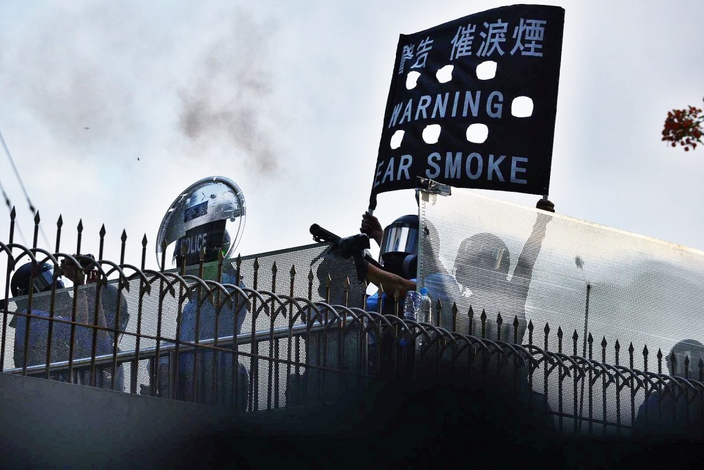 長沙灣警署警察舉黑旗後施放催淚彈。