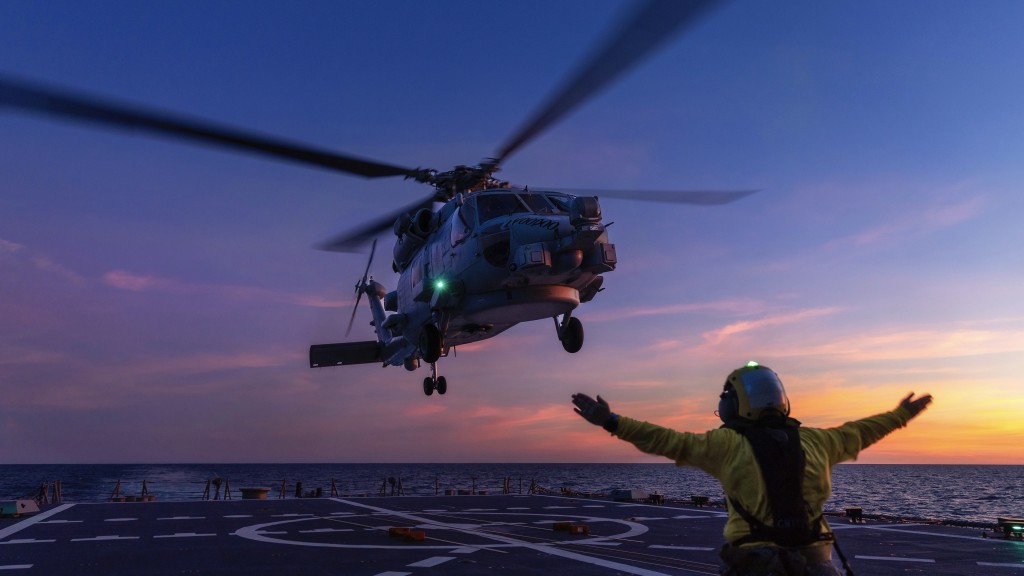  澳洲国防军一架海鹰直升机在飞行任务中，准备降落在霍巴特号航空母舰的甲板上。 美联社