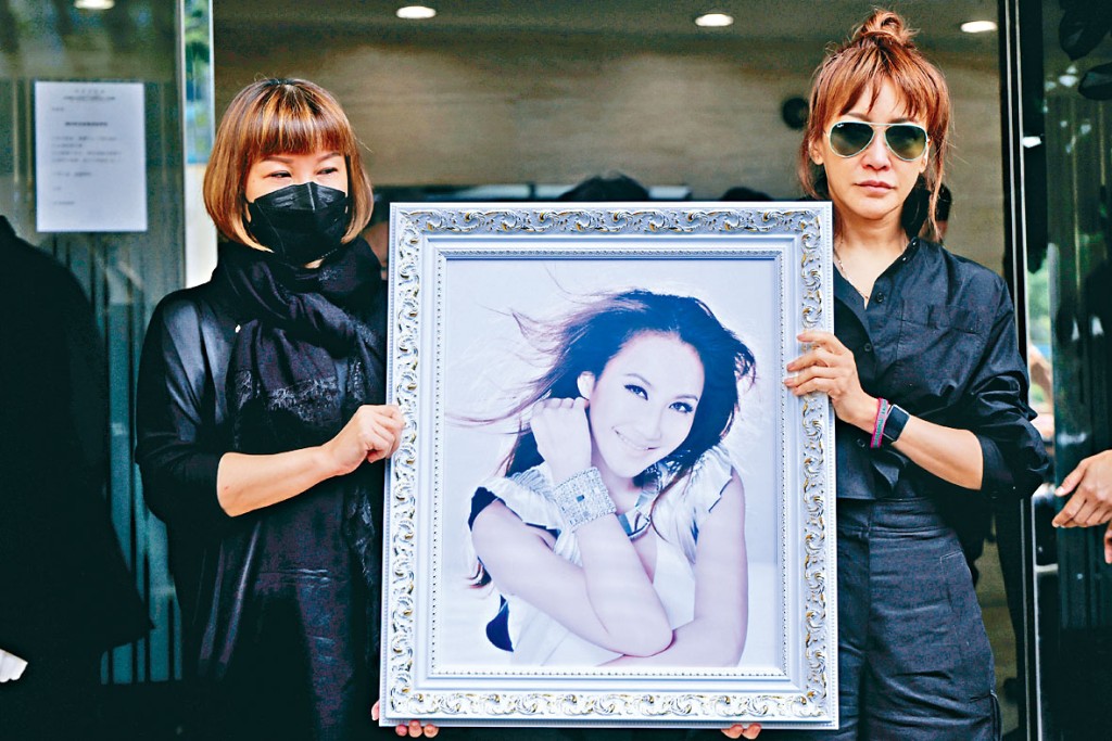 在Coco和丈夫的「婚後協議書」中擔任見證人的二姐李思林（右），手捧Coco遺照送最後一程。
