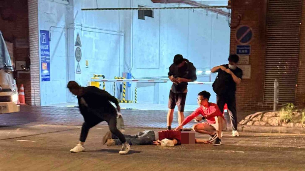 男子頭部受傷倒臥路中，多名途人上前協助。網上圖片