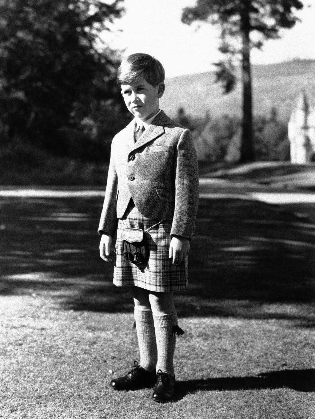 7岁的查理斯在巴尔莫勒尔格城堡，穿着代表皇室的“巴尔莫勒尔格纹”的苏格兰裙。 美联社