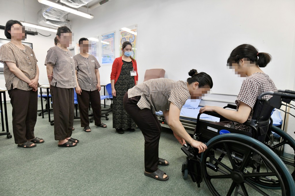 導師向女學員講解如何照顧長者及病患人士。 盧江球攝 導師向女學員講解如何照顧長者及病患人士。 盧江球攝