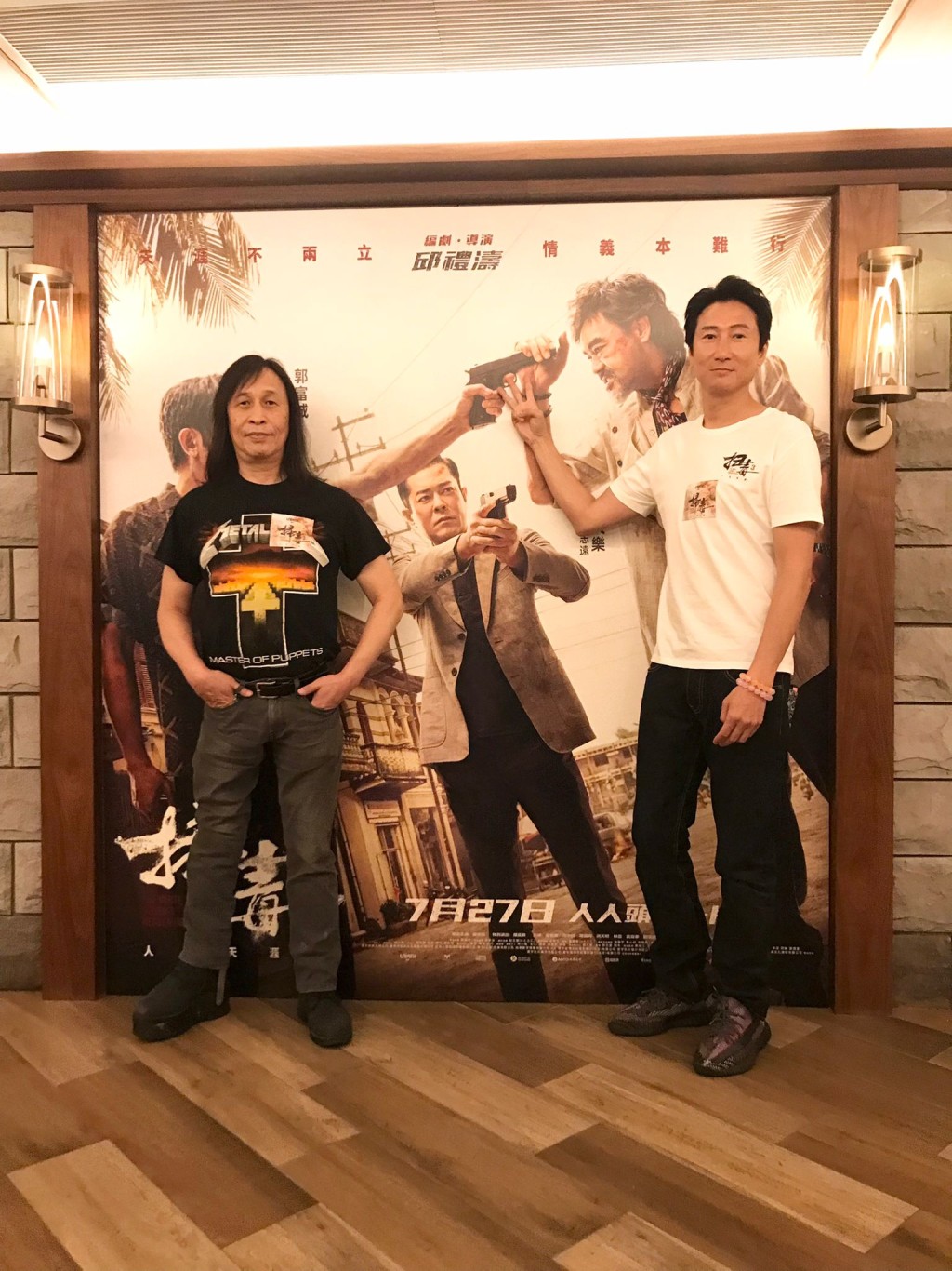 导演（左）与洪天明在海报前合照。