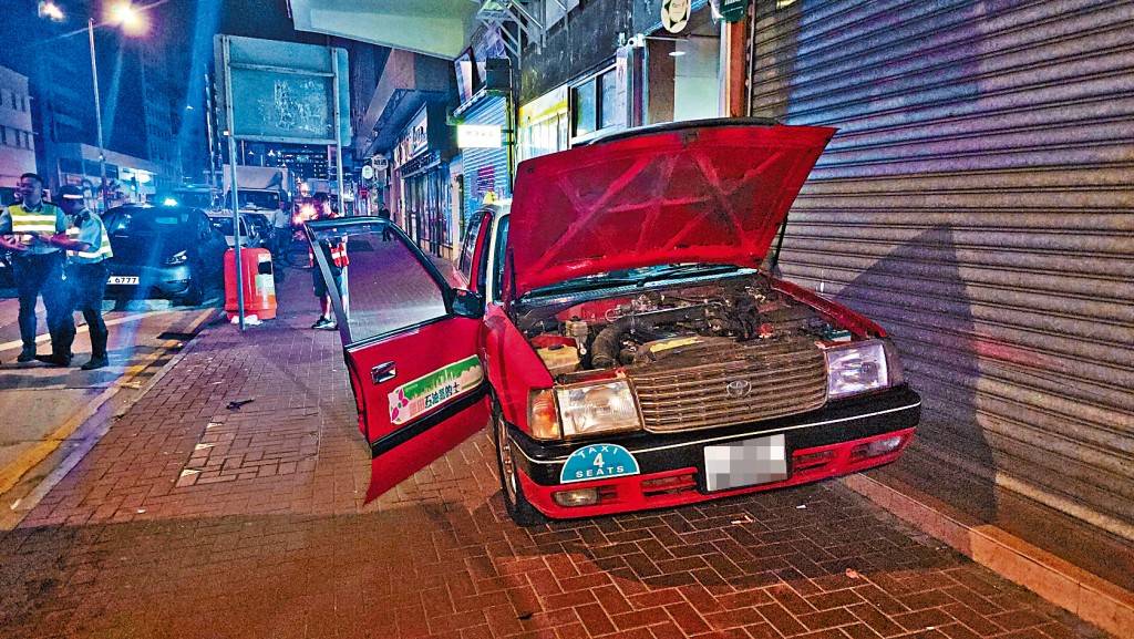 的士倒車失控撞向一輛貨車後再撞毀地舖鐵閘,車門損毀。
