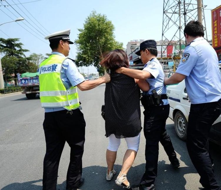女司機最後被警噴射辣椒水強制帶上警車。