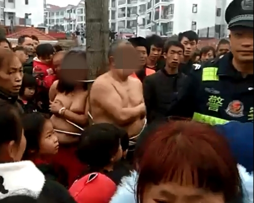 偷情男女被赤裸綁在樹上。影片截圖