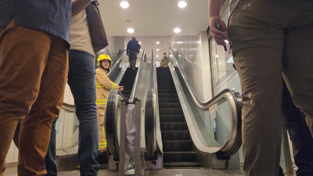 消防及工程人員檢查失火的扶手電梯。黃文威攝