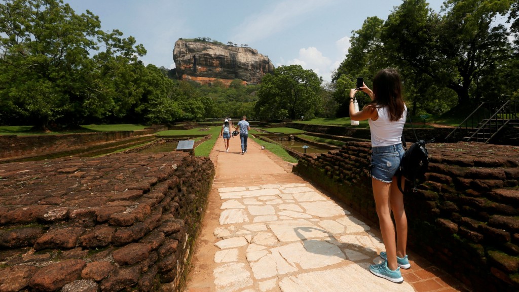 遊客在錫吉里耶（Sigiriya）獅子岩下拍照。 路透社