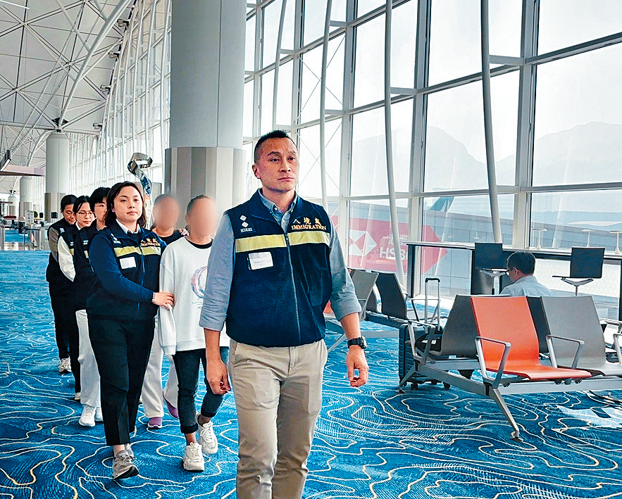 被遣返人士在入境處人員押送下離港。