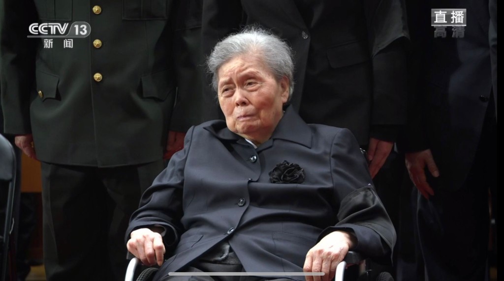遺孀王冶坪坐在輪椅，神情悲痛。