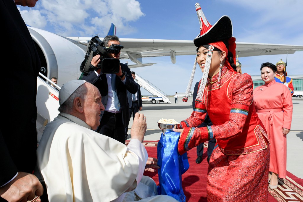 教宗飞抵乌兰巴托机场时，一名传统装扮女子送上干乳酪给他品尝。路透社