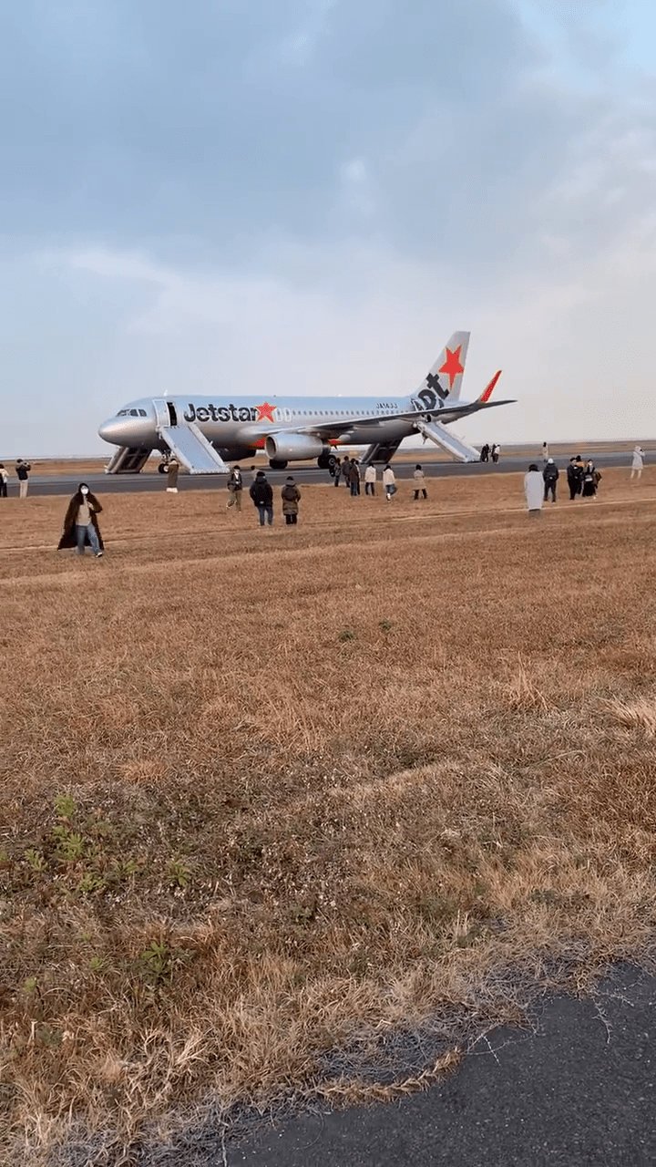 捷星航空班机弹出四条逃生滑梯，乘客正在疏散。