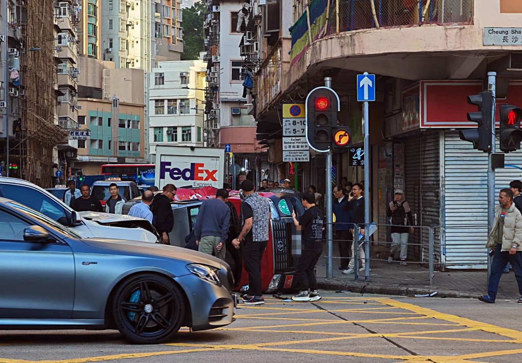 的士翻側路邊，大批途人幫手救人。網圖