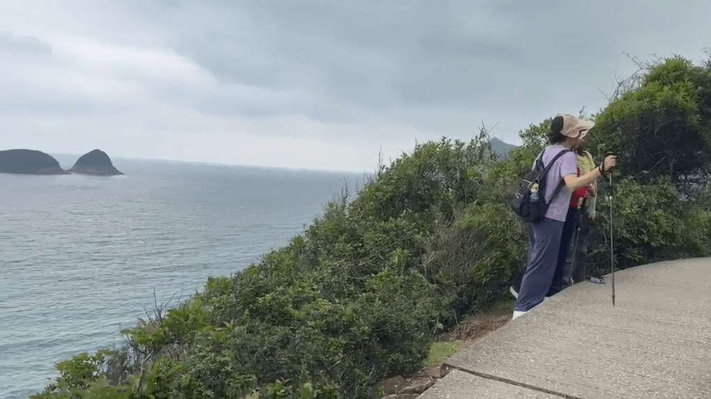 有遊客在微雨潮濕的環境下,仍走出步行徑外範圍在崖邊合照打卡。 有遊客在微雨潮濕的環境下,仍走出步行徑外範圍在崖邊合照打卡。