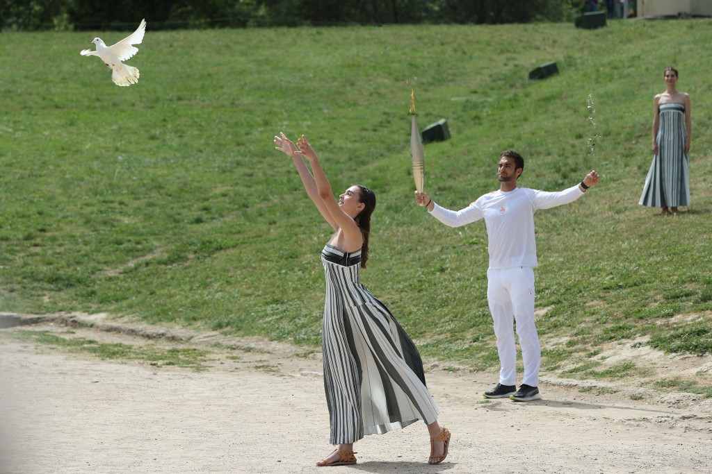扮演女祭司的演員在儀式上放飛鴿子。 新華社