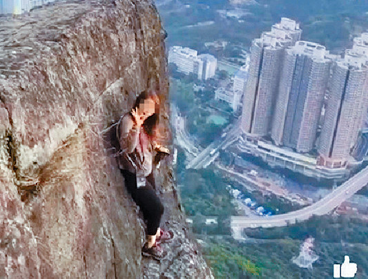 ■該名女子，徒手攀飛鵝山自殺崖，更轉身向拍片者舉起「ok」手勢。
