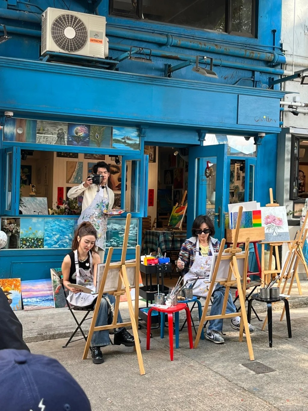 两人在街头画画，吸引不少人围观。