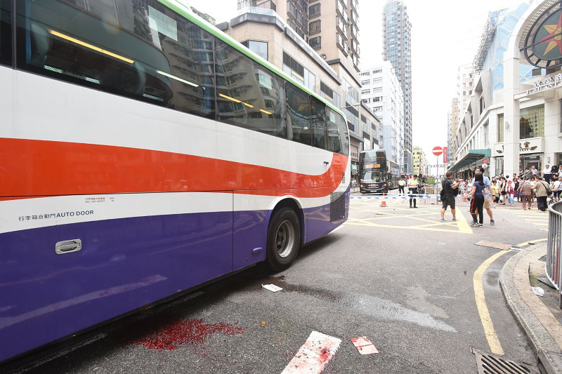 兩途人被捲入車底，現場路面染有血跡。