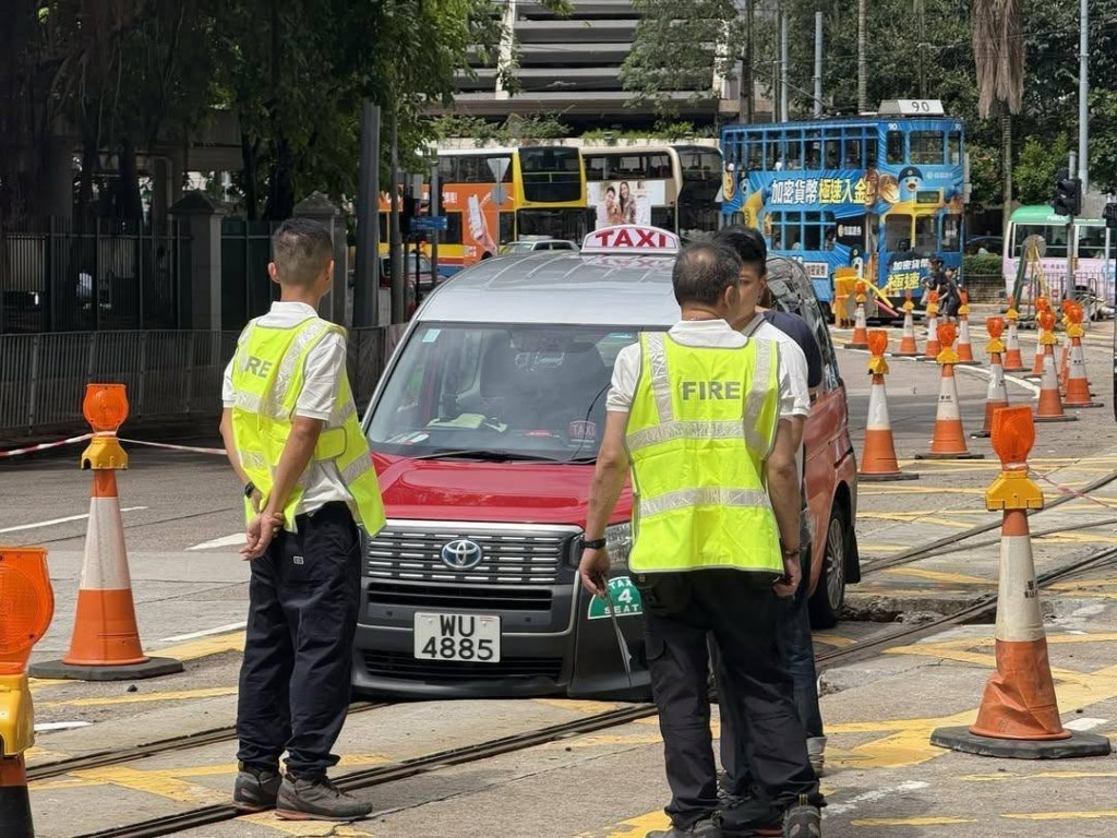 一轉的士衝入維修中的電車路軌，其前轆陷入坑內被困。網上圖片