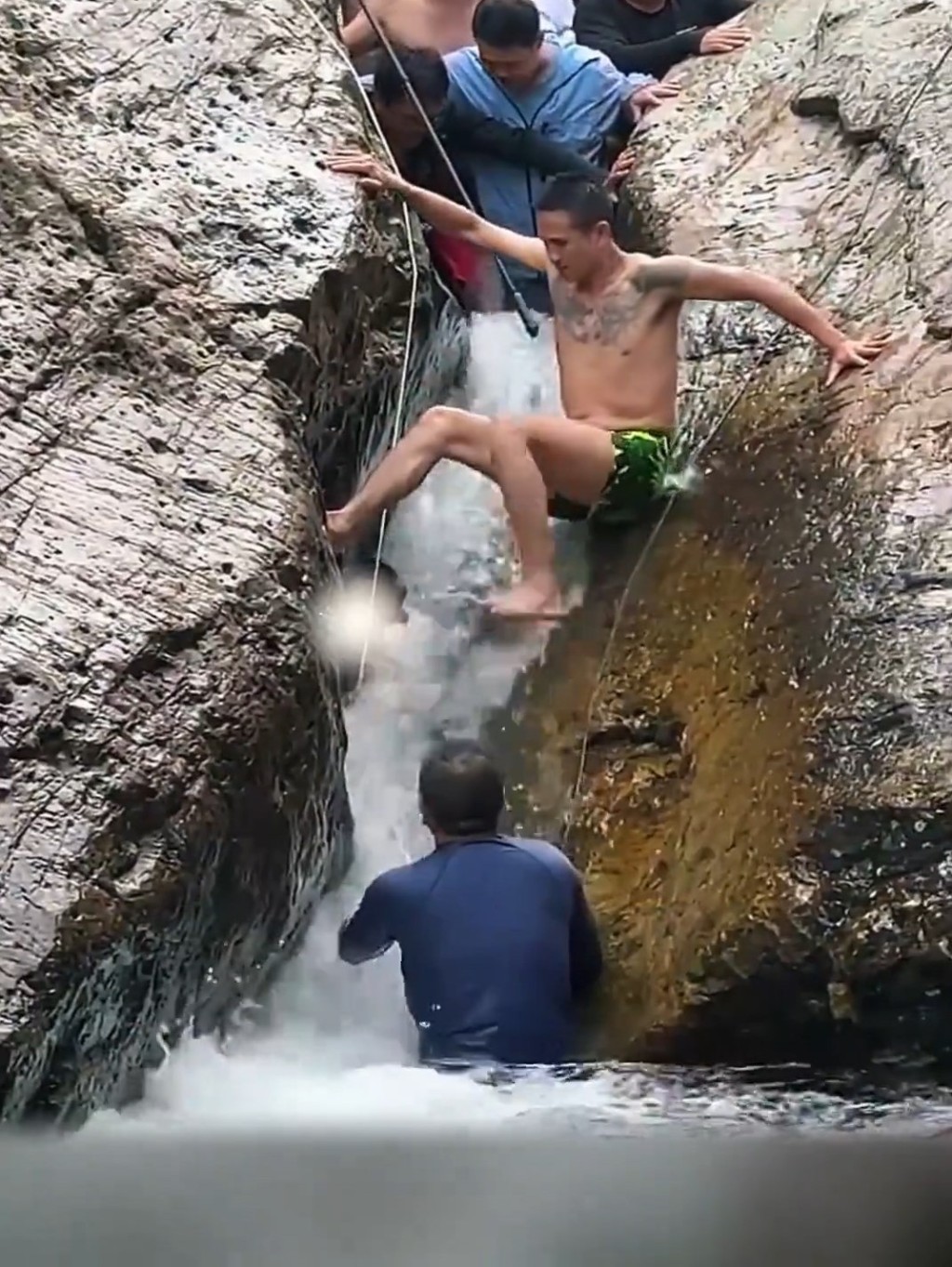 上方位置的遊客築起人牆,希望讓男子能盡快救出被困石縫的男孩。 上方位置的遊客築起人牆,希望讓男子能盡快救出被困石縫的男孩。