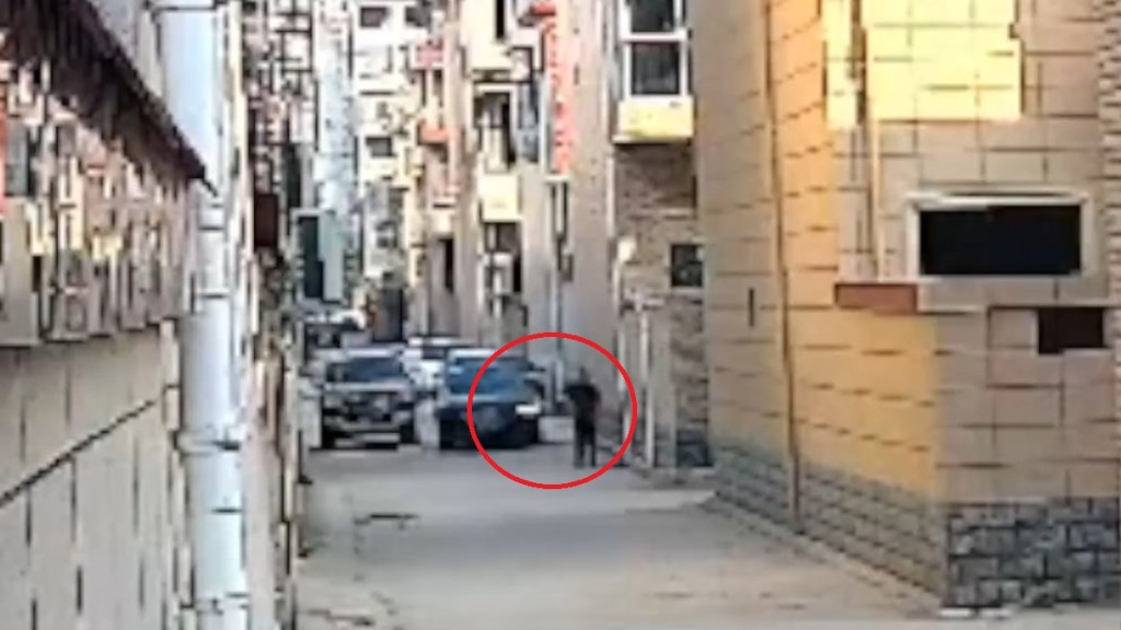 男子被黑色汽车辗过前一刻。影片截图