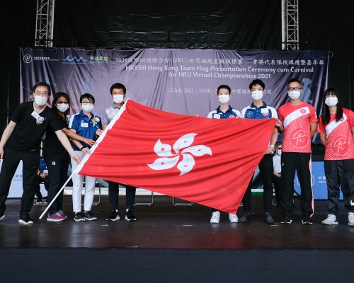 民政事务局体育专员杨德强将香港区旗交予香港队总教练及运动员代表。 公关图片