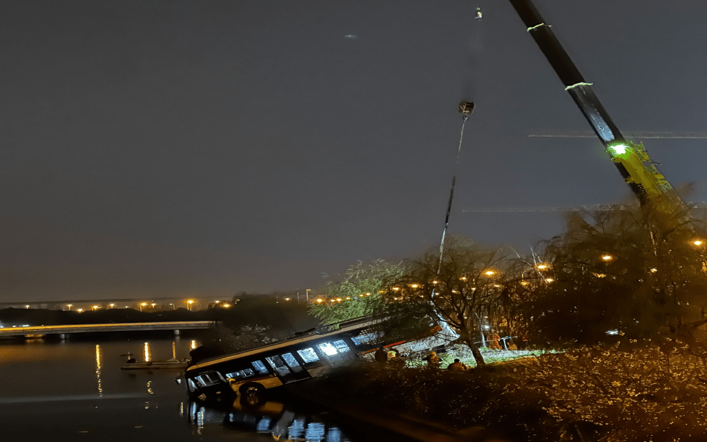 堕河的71号巴士27日凌晨，由吊车进行打捞。