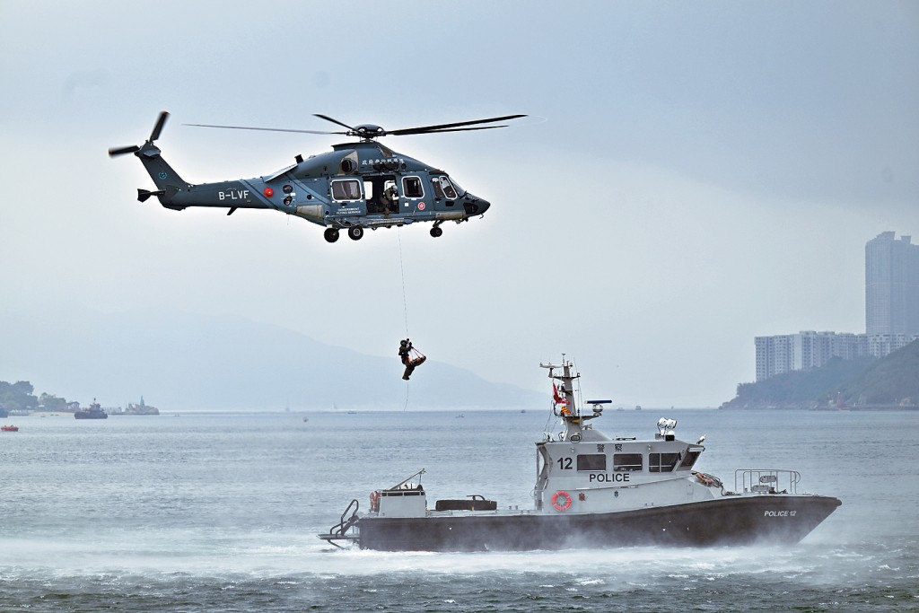 飞行服务队的队员在模拟救援行动中，游绳到水警轮上拯救伤者。