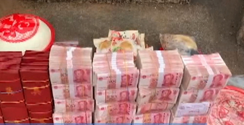 一叠叠百元人民幣整齊堆放在先人墓碑前。網圖