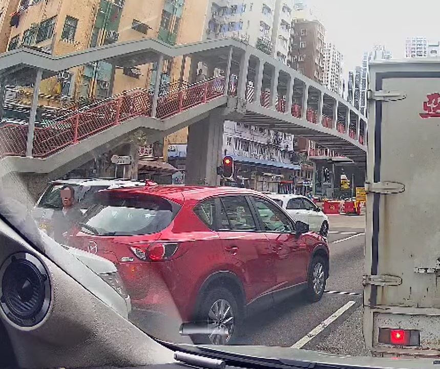 兩人由鏡前打至鏡頭外，紅色私家車女子下車勸止。fb車cam L（香港群組）影片截圖