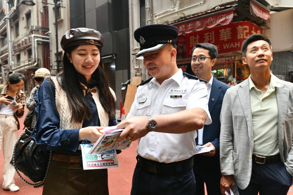 中區警區副指揮官羅國凱向區內人士及遊客派發宣傳單張。盧江球攝