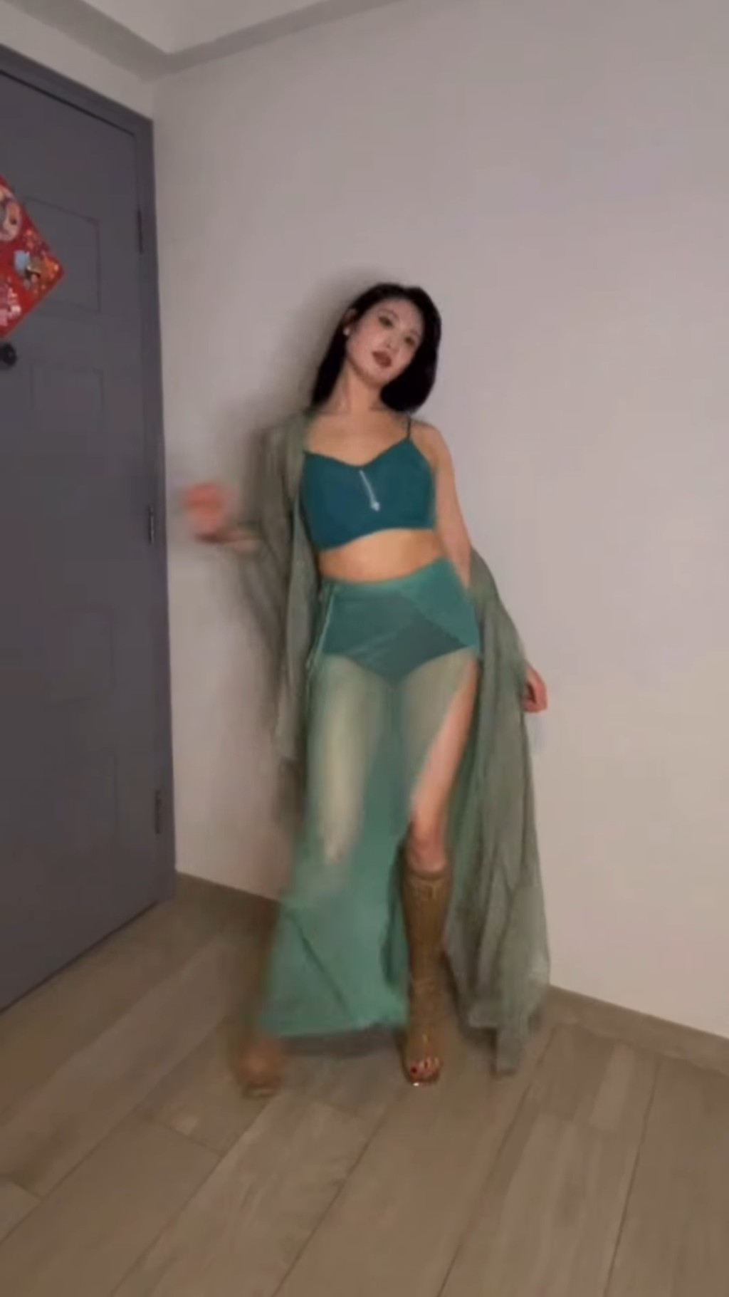 林佑蔚身穿湖水綠短身上衣和熱褲，配上誘惑露趾長靴，外披一件薄紗若隱若現。